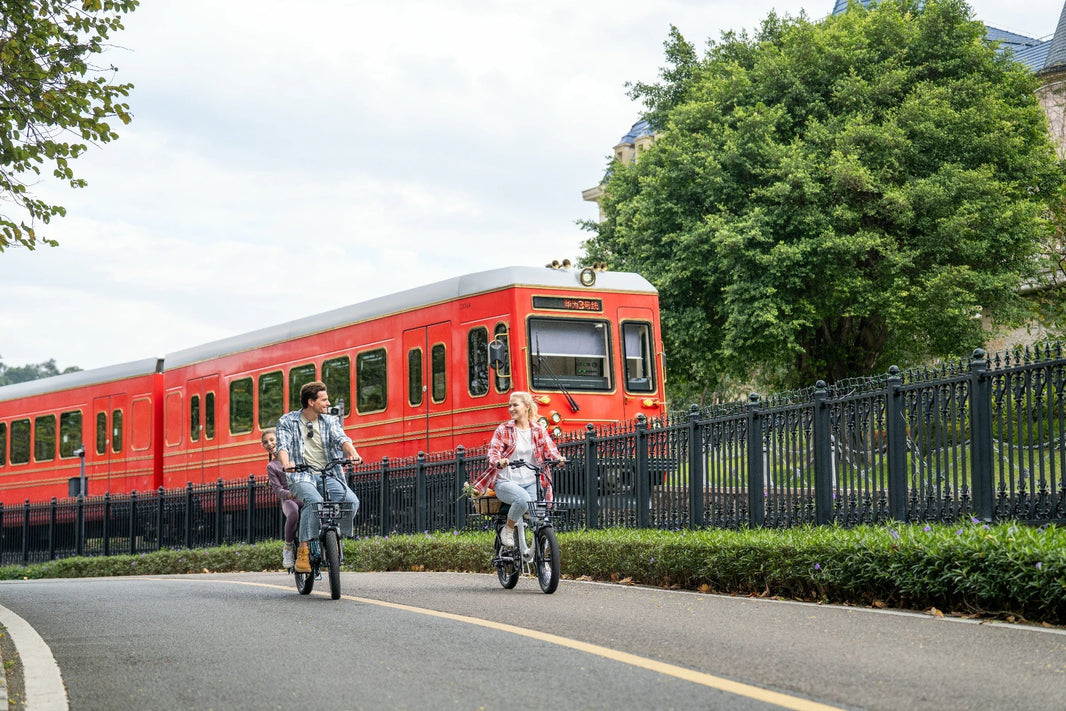 DYU C9 folding e-bike beside a red train in Europe
