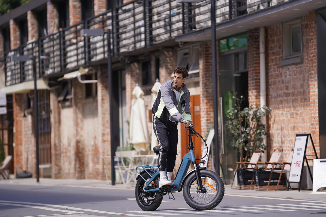 DYU FF500 fat-tire folding e-bike riding past a street cafe