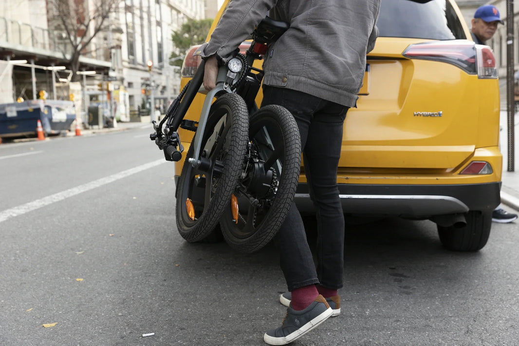 Folding e-bike buying checklist with DYU T1 carried on a city street